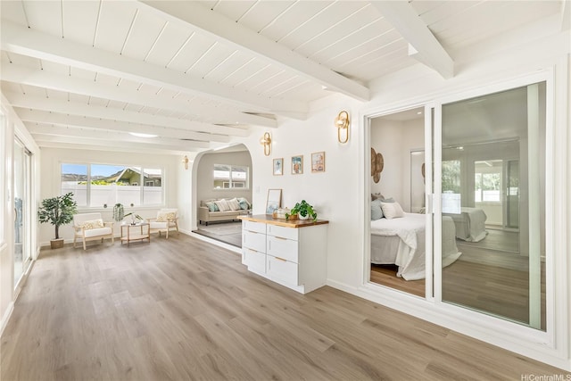 sunroom / solarium with arched walkways, french doors, beam ceiling, and a wealth of natural light