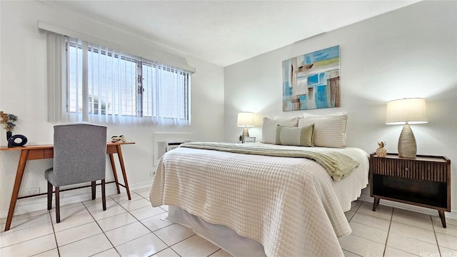 tiled bedroom featuring an AC wall unit and baseboards