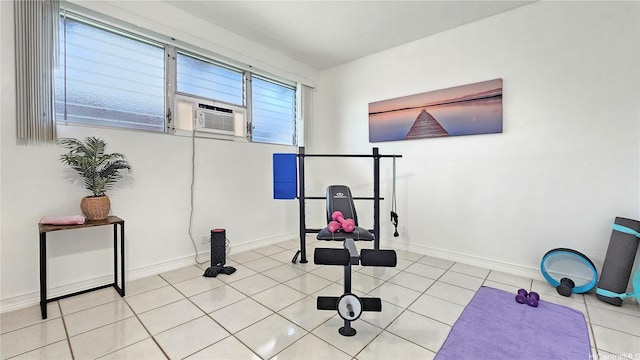 exercise area featuring baseboards, cooling unit, and light tile patterned floors