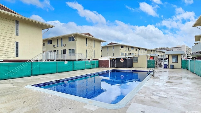 community pool featuring fence and a residential view