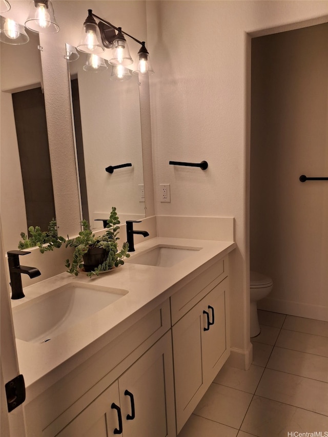 full bathroom featuring double vanity, tile patterned flooring, toilet, and a sink