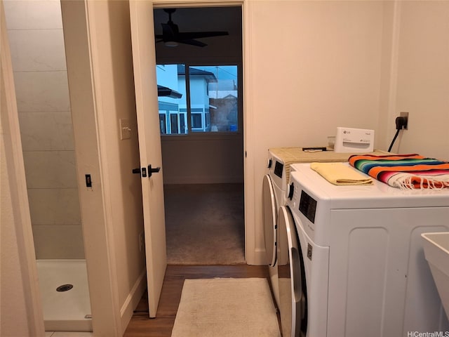 washroom featuring washing machine and dryer, wood finished floors, ceiling fan, and laundry area
