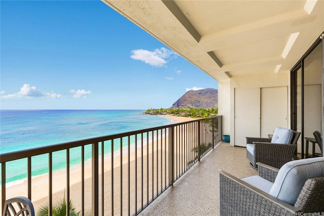 balcony with a beach view and a water and mountain view