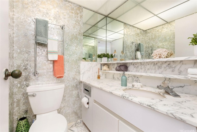 bathroom featuring tile walls, toilet, and vanity