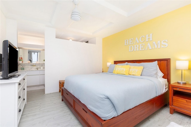 bedroom featuring light wood-style flooring and ensuite bath