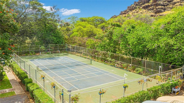 view of tennis court featuring fence