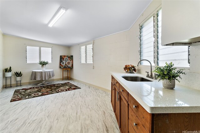 1727 Ema Pl, Honolulu, HI 96819 - kitchen featuring light stone countertops, brown cabinetry, a sink, and lofted ceiling