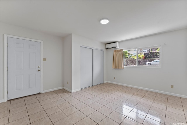 unfurnished bedroom with light tile patterned floors, baseboards, a wall unit AC, and a closet