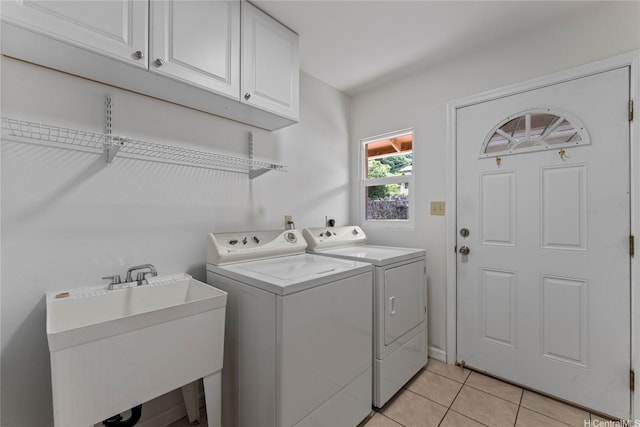 laundry area featuring a sink, cabinet space, light tile patterned floors, and washer and dryer