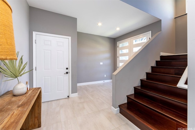 foyer featuring recessed lighting, baseboards, and stairs