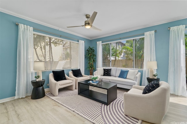 living area featuring ornamental molding, ceiling fan, wood finished floors, and baseboards