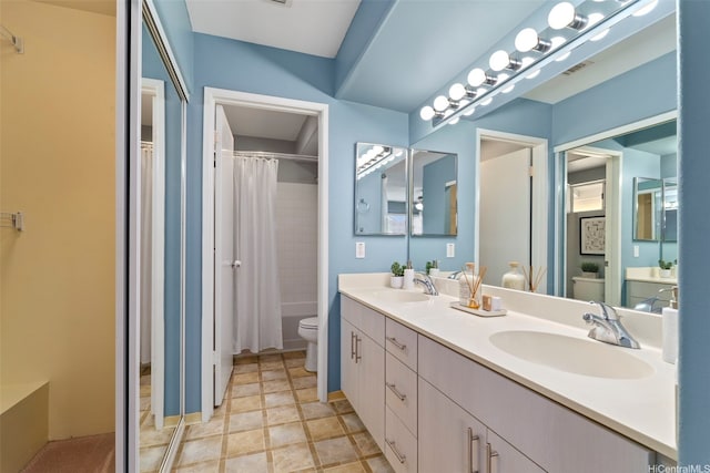 full bathroom featuring toilet and double vanity
