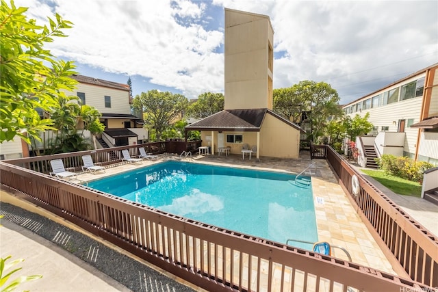 community pool with fence and a patio area