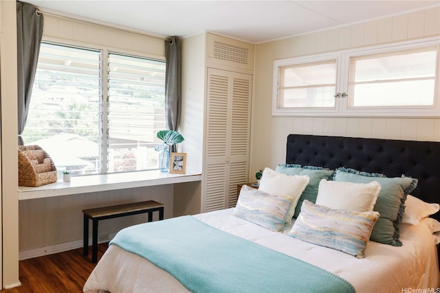 bedroom with dark wood-type flooring, a closet, and multiple windows