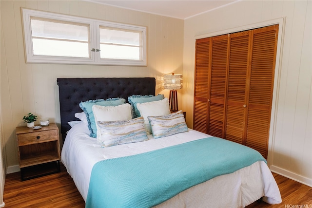 bedroom with wood finished floors and a closet