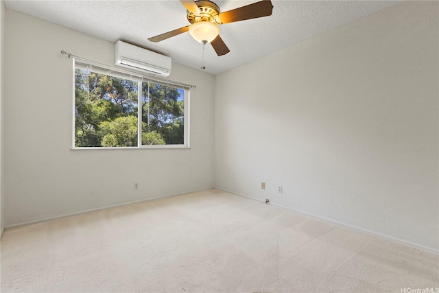 98-1724 Kaahumanu St Unit 16C, Pearl City, HI 96782 - spare room featuring a textured ceiling, an AC wall unit, baseboards, ceiling fan, and light carpet