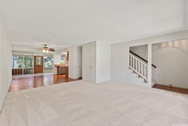 98-1724 Kaahumanu St Unit 16C, Pearl City, HI 96782 - unfurnished living room with a textured ceiling, stairway, a ceiling fan, and carpet