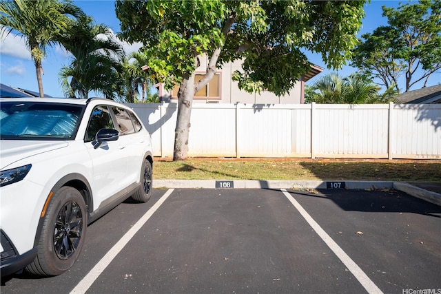 uncovered parking lot featuring fence