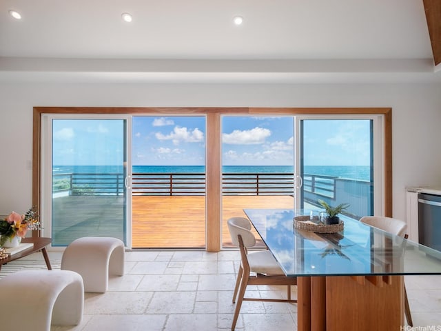 interior space with stone tile floors, recessed lighting, and a water view