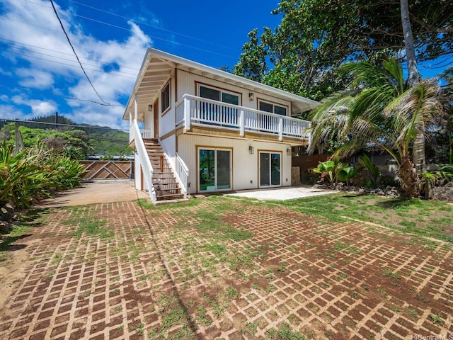 back of house featuring fence, stairs, and a patio