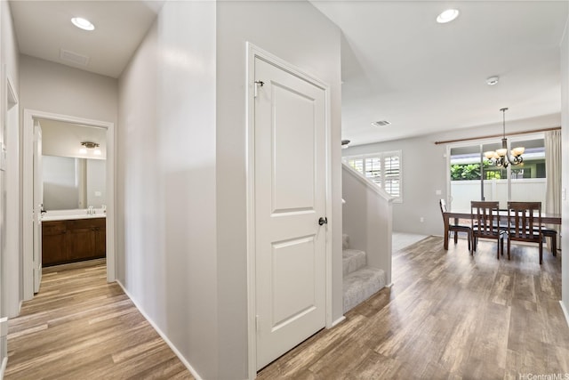 91-1015 Akai St, Ewa Beach, HI 96706 - corridor featuring light wood-style flooring, stairway, a chandelier, and recessed lighting