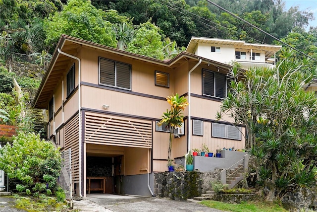 view of front facade with driveway and stairs