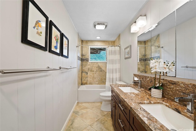 bathroom featuring double vanity, shower / bath combo with shower curtain, toilet, and a sink