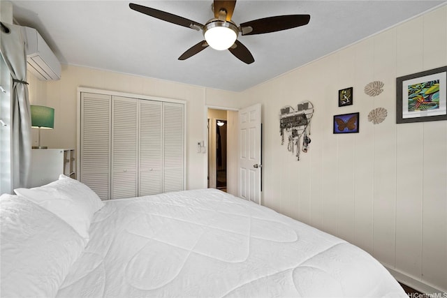 bedroom featuring a ceiling fan, a closet, and a wall unit AC