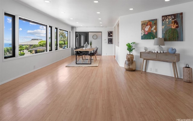 living area with baseboards, recessed lighting, and light wood-style floors