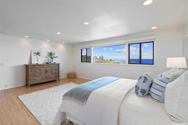 bedroom with recessed lighting, wood finished floors, and baseboards