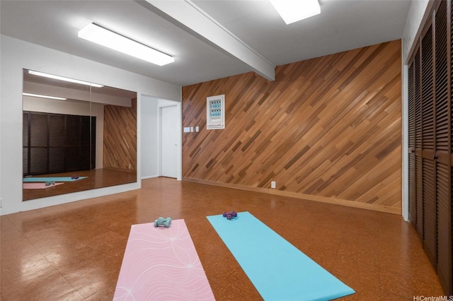 workout area featuring wood walls and tile patterned floors