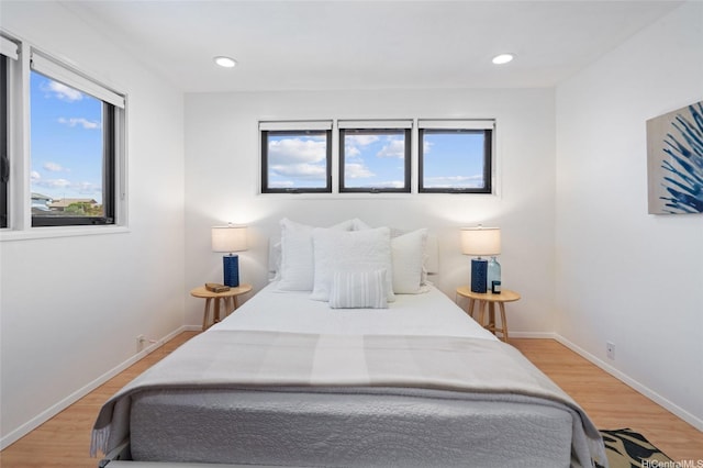 bedroom with recessed lighting, baseboards, multiple windows, and light wood-type flooring