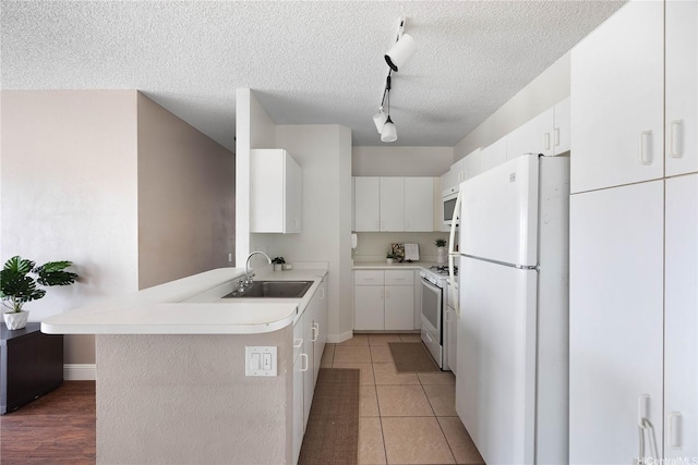 91-568 Puamaeole St Unit 50T, Ewa Beach, HI 96706 - kitchen featuring white appliances, a sink, track lighting, a peninsula, and a textured ceiling