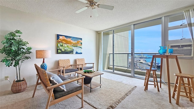 carpeted living room with ceiling fan, a water view, cooling unit, a textured ceiling, and a wall of windows