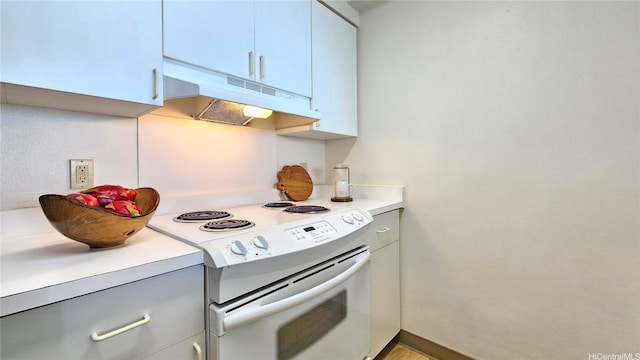 kitchen featuring electric stove, light countertops, and under cabinet range hood