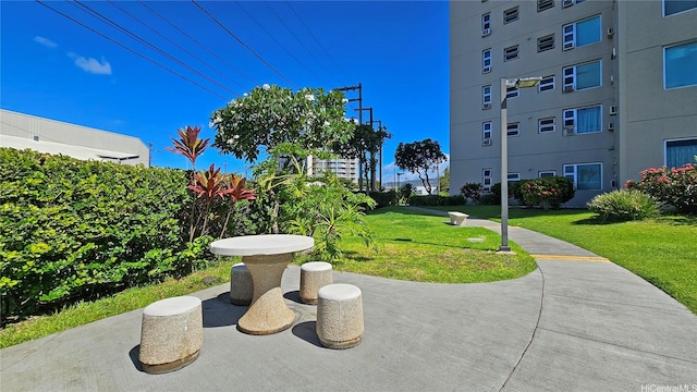 view of community with a patio and a lawn