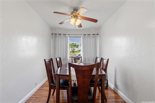 dining area featuring baseboards, ceiling fan, and wood finished floors