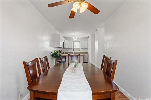 dining room with a ceiling fan and baseboards