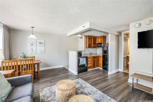 living area with a textured ceiling, dark wood-style floors, and baseboards