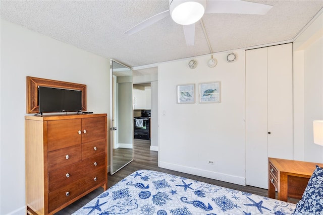 bedroom featuring a textured ceiling, a ceiling fan, dark wood finished floors, and baseboards