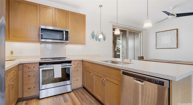 84-928 Maiola St Unit 76, Waianae, HI 96792 - kitchen featuring stainless steel appliances, a sink, a peninsula, light countertops, and hanging light fixtures