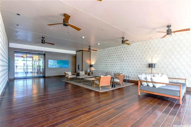 living room with ceiling fan, baseboards, wood finished floors, and wallpapered walls