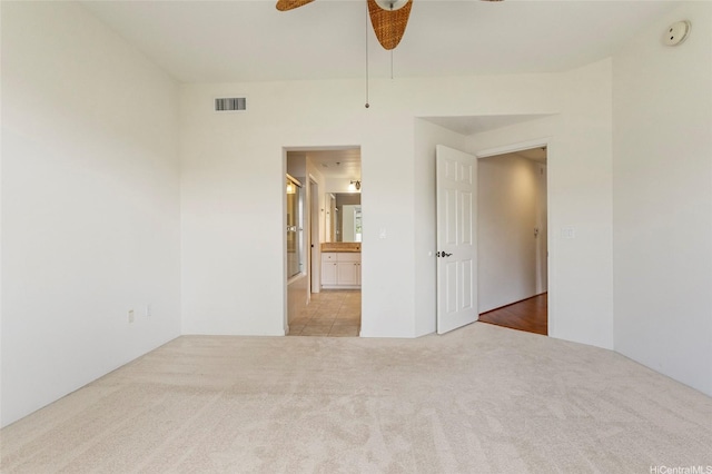 spare room with visible vents, a ceiling fan, and carpet flooring