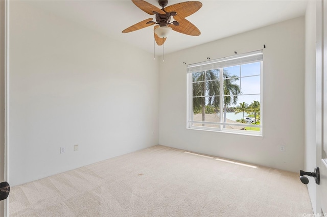 carpeted spare room with a ceiling fan