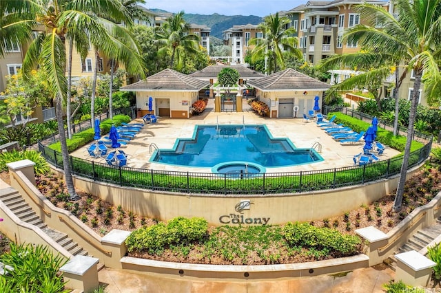 pool with a mountain view, fence, and a patio area