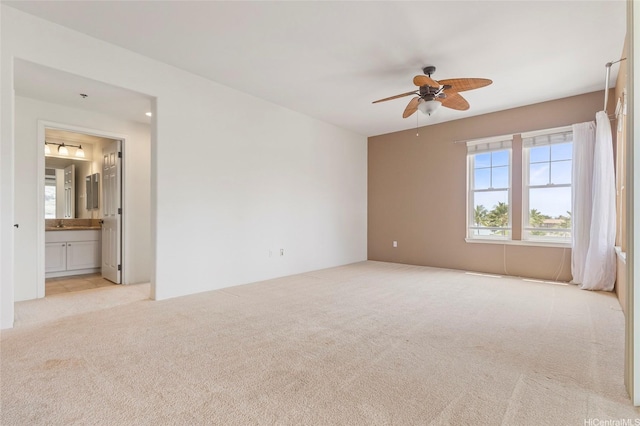 carpeted spare room with a ceiling fan