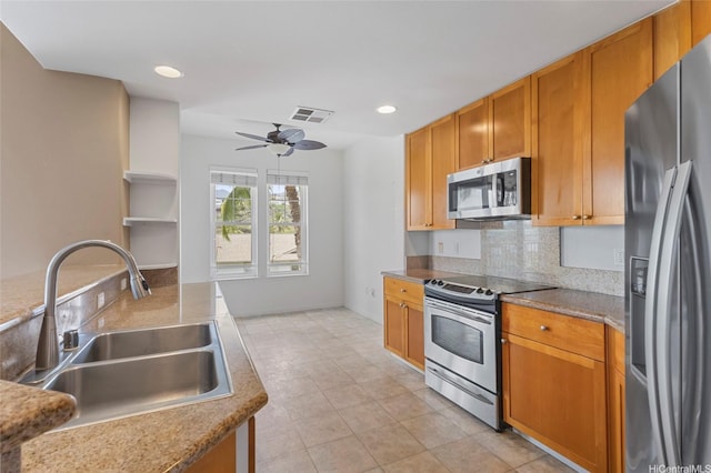 kitchen with a sink, decorative backsplash, a ceiling fan, visible vents, and appliances with stainless steel finishes