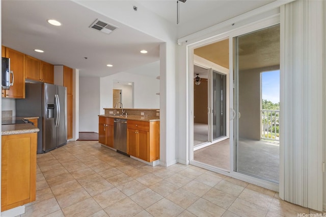 kitchen featuring recessed lighting, brown cabinetry, appliances with stainless steel finishes, a sink, and visible vents