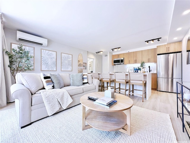 201 Ohua Ave Unit 610, Honolulu, HI 96815 - living area featuring light wood finished floors, an AC wall unit, arched walkways, and rail lighting