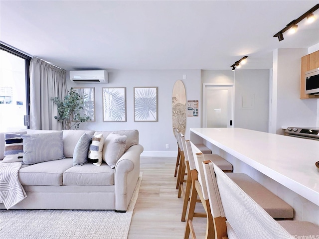 201 Ohua Ave Unit 610, Honolulu, HI 96815 - living room with baseboards, rail lighting, light wood finished floors, and a wall unit AC